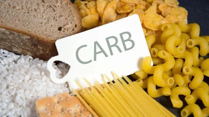 Image of various carbohydrate foods, including bread, rice, pasta, and cornflakes, with a label reading "CARB."