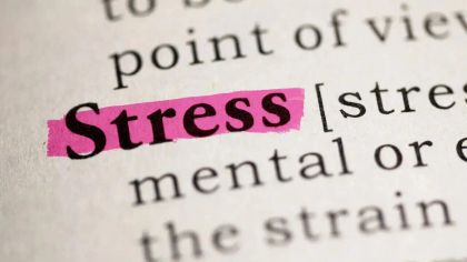 Close-up of a dictionary page with the word "stress" highlighted in pink.