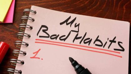 A notebook with "My Bad Habits" written on the cover, and a black marker resting beside it.